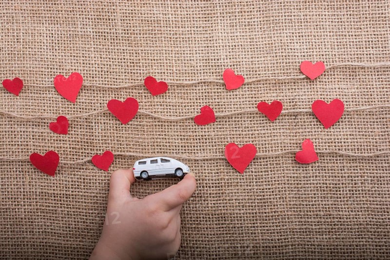 Love concept with car and paper heart on linen threads