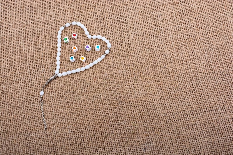 Heart shaped cubes in hand by inside a praying beads
