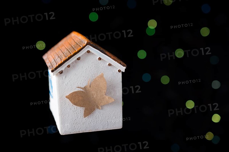 Paper butterfly on a Model house on a bokeh light