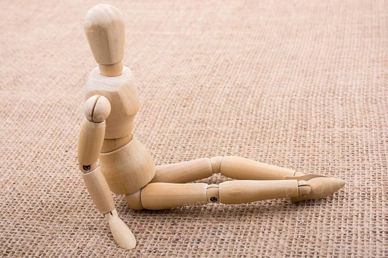 Wooden dolls of a man posing on canvas