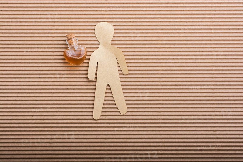 Paper man shape with a heart shaped bottle beside