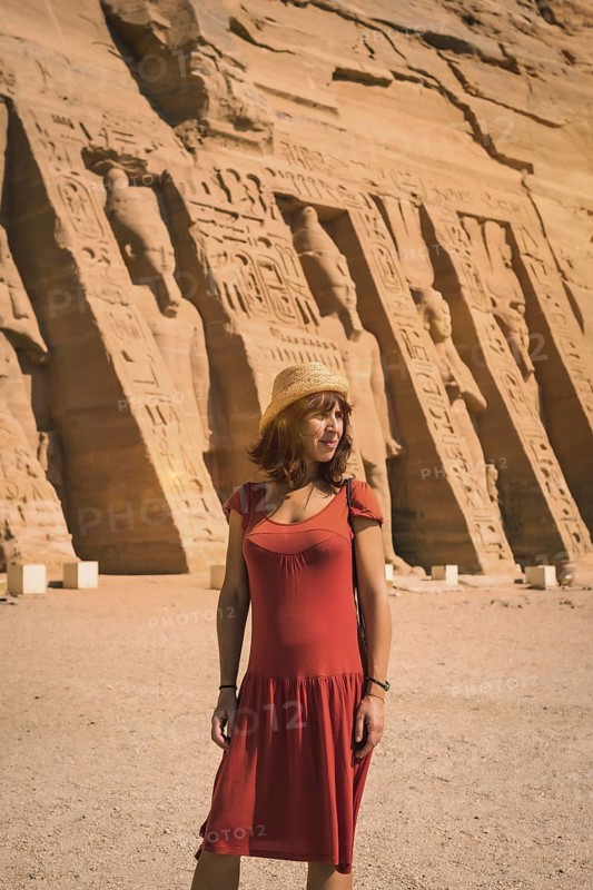 A young girl in red dress visiting the Egyptian Temple of Nefertari near Abu Simbel in southern Egypt in Nubia next to Lake Nasser. Temple of Pharaoh Ramses II