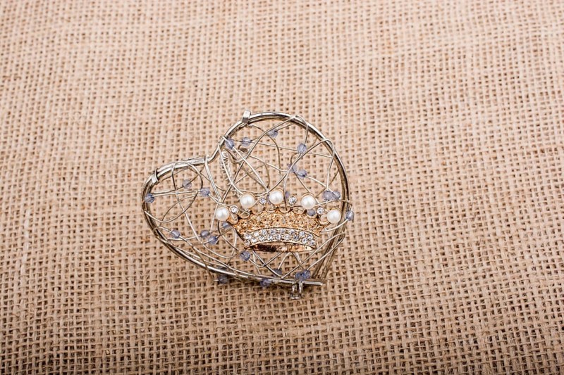 Golden color crown model with pearls on brown background
