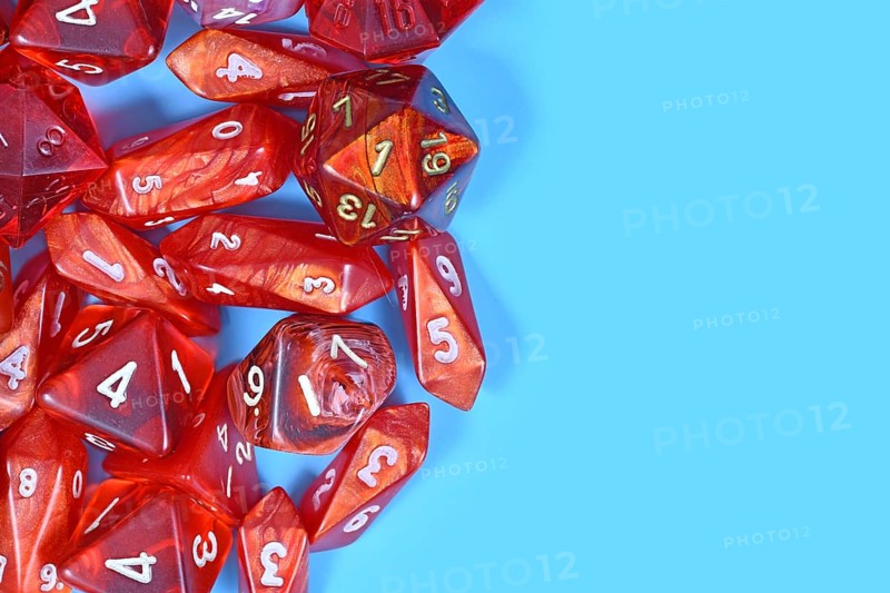 Roleplay game background with different red RPG dices at side of light blue background with copy space