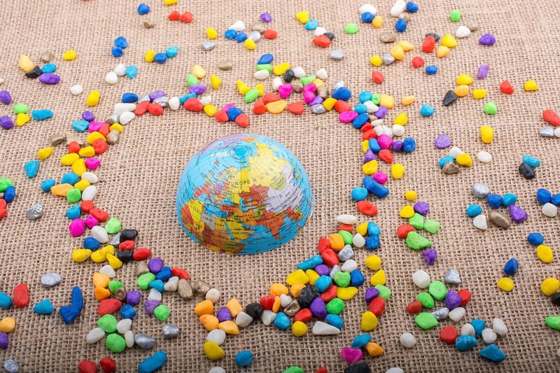 Globe in the heart form shaped by colorful pebbles
