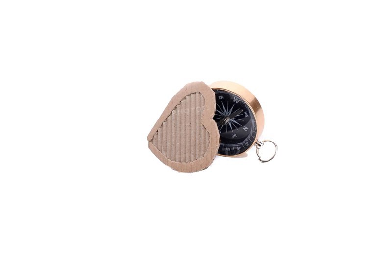 Heart shape paper and compass on a white background
