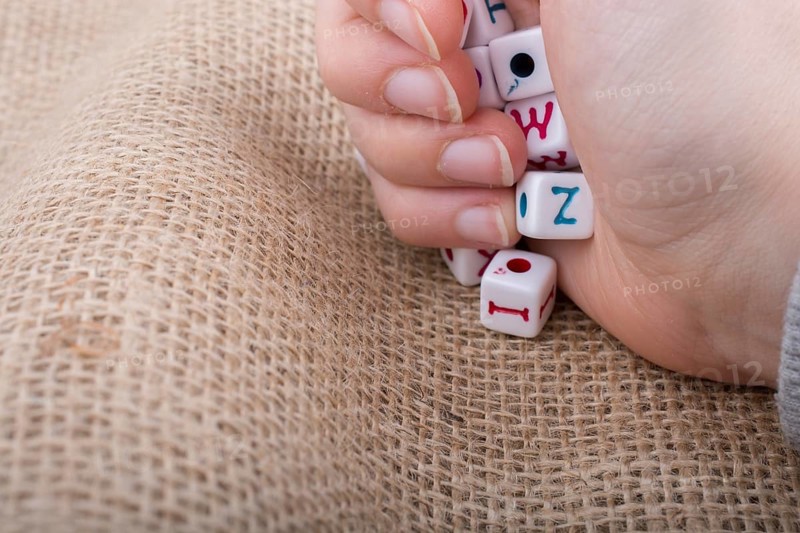 Colorful alphabet letter cubes in handon a canvas background