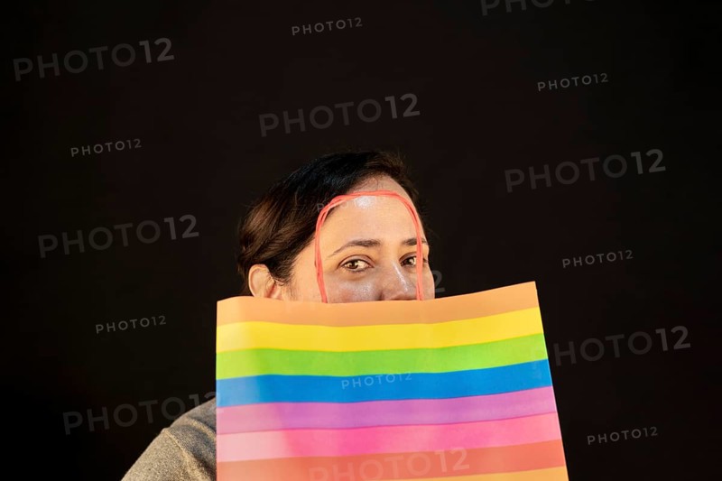 Woman holding lgbt bag. Joy of consumption. Purchases