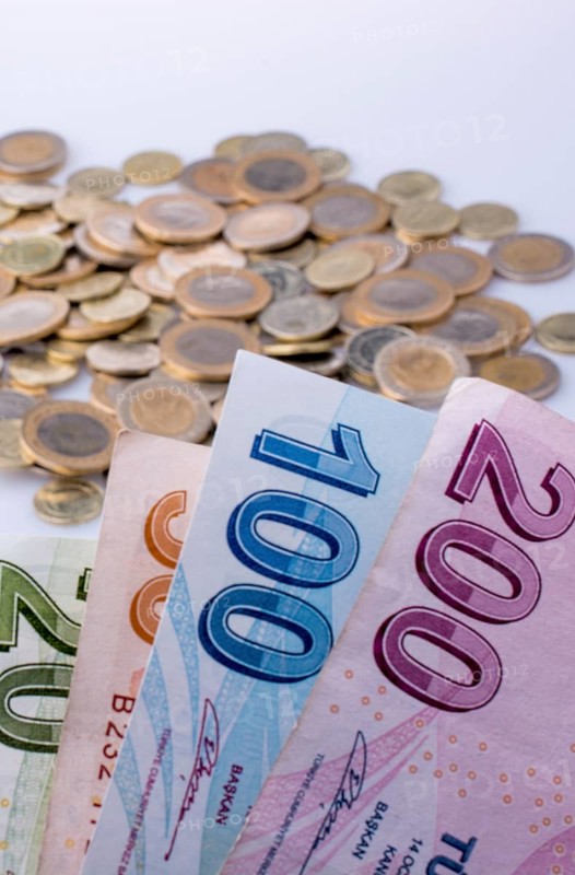 Turkish Lira coins and banknotes side by side on white background