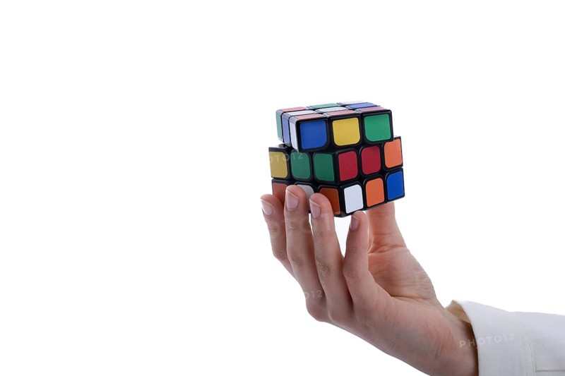 Child holding a Rubik's cube in hand on a white background