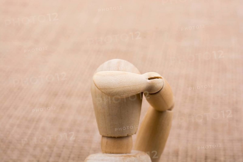 Wooden dolls of a man posing on canvas