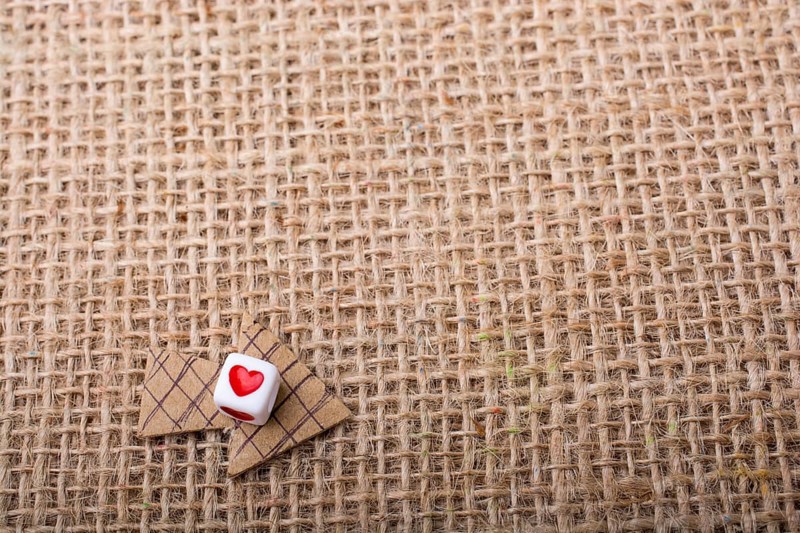 Love cubes on arrow cut out of brown paper on canvas