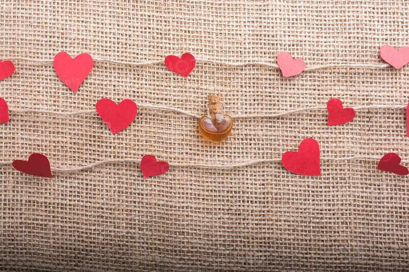 Heart shaped bottle and papers on linen threads