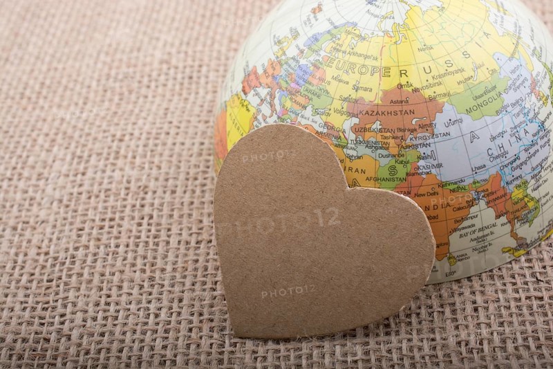 Heart shaped object by a model globe on canvas