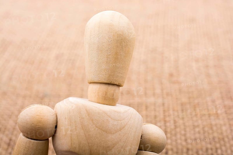 Wooden dolls of a man posing on canvas