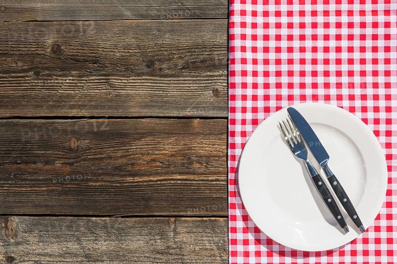 White plate checkered table cloth wooden textured plank