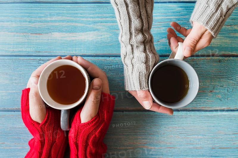 Hands holding cups tea