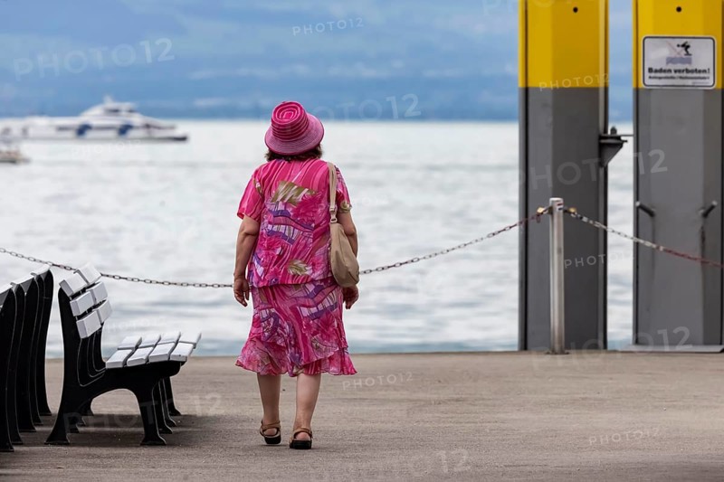 Tourist in colourful clothes on the jetty at Lake Constance