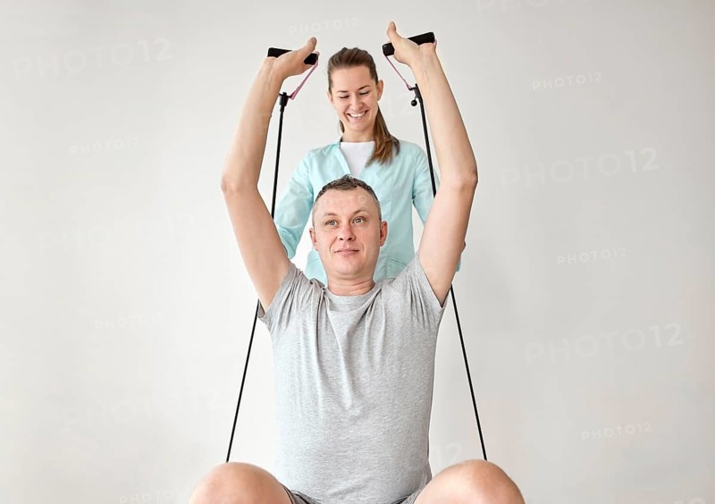 Therapist undergoing physical therapy male patient