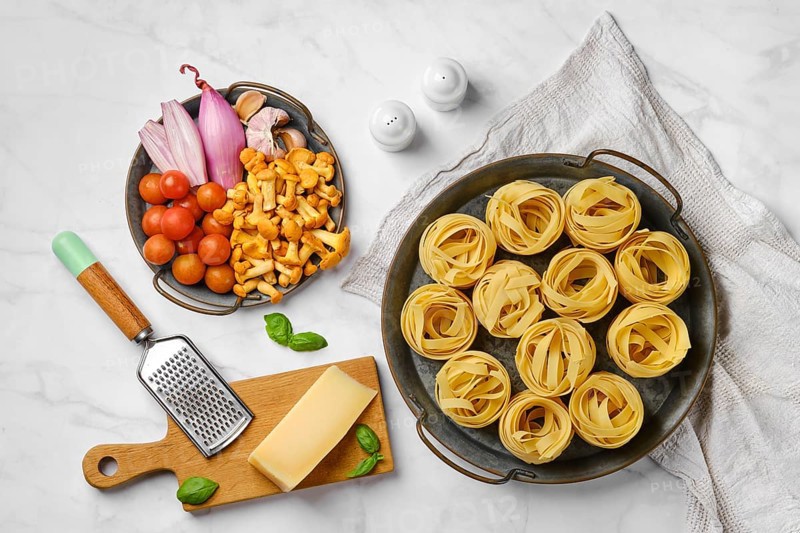 Trays with raw ingredients for mushroom pasta