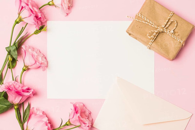 Blank paper with envelop fresh pink flower brown wrapped gift box pink background