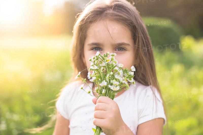 Girl smelling white flowers