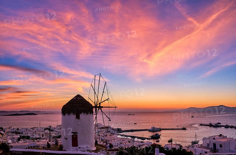 Famous traditional Greek windmill overlook civil port and harbor of Mykonos