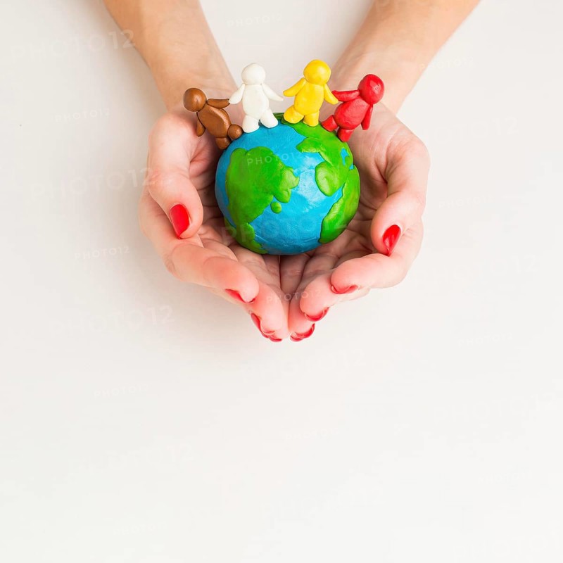 Top view hands holding globe with people figurines