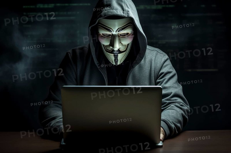 Hacker with Anonymous mask on notebook