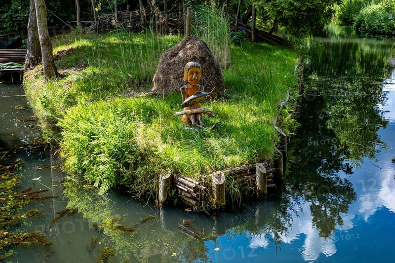 Wooden figure with fish in hands on the bank of the Spree