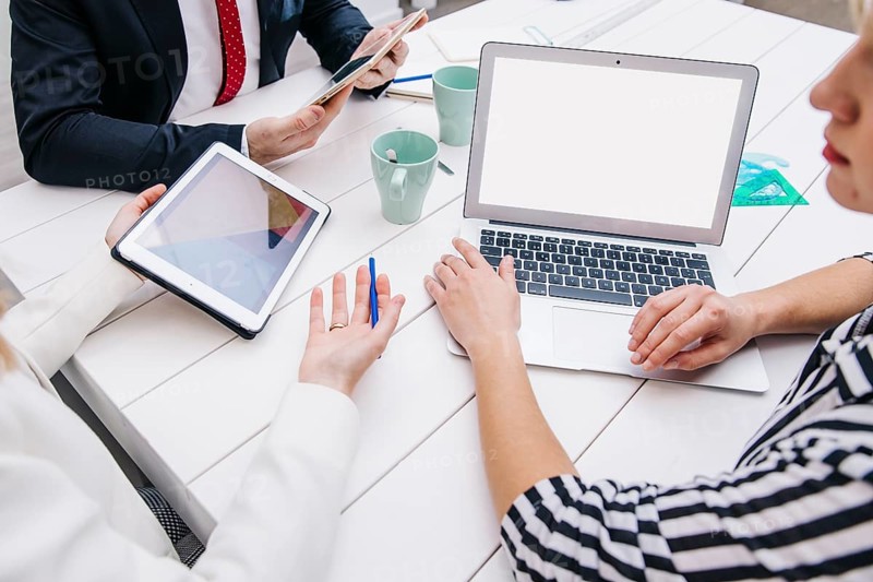 Colleagues with devices working desk