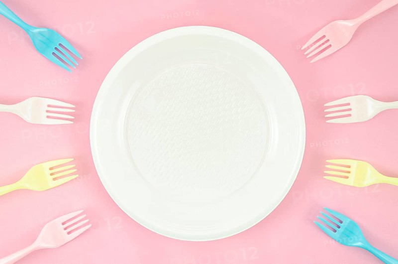 Colorful plastic dishes pink background