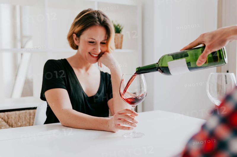 Hand pouring wine girlfriend