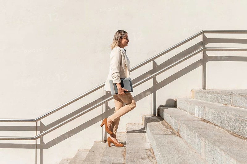 Full shot woman climbing up stairs