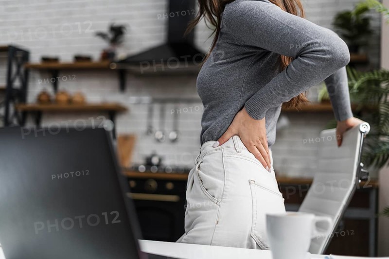Side view woman having backache while working from home
