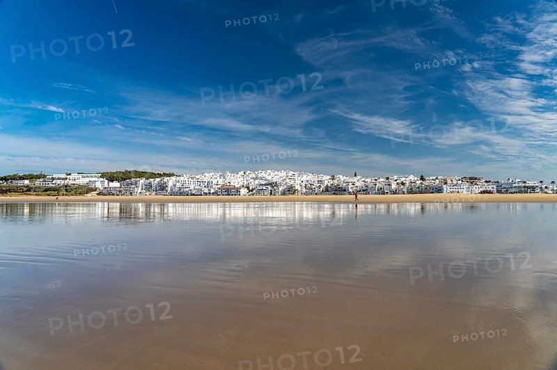 The town view of Conil reflected on the beach Playa De Los Bateles