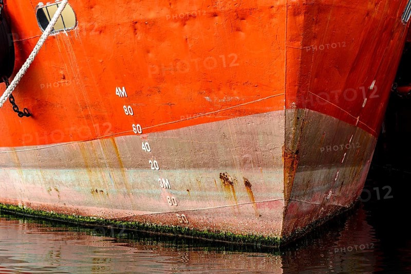 Old ship bow showing signs of deterioration with rust and parasites attached to the hull