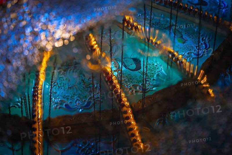 The colourful lights of the Mainfest are reflected in a puddle. The Mainfest on the Mainkai
