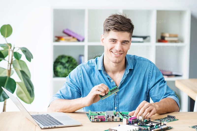 Smiling young male it technician with hardware equipment s
