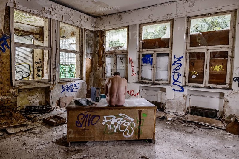 Man dressed in suit wearing VR glasses in a dilapidated office building