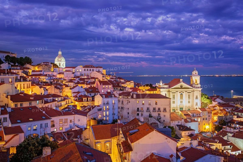 View of Lisbon famous view from Miradouro de Santa Luzia tourist viewpoint over Alfama old city district at night. Lisbon