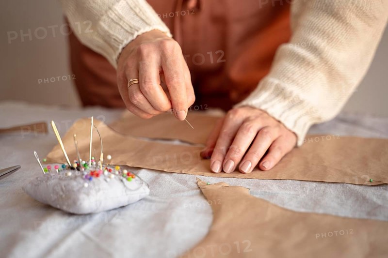 Tailor woman using needle thread sew