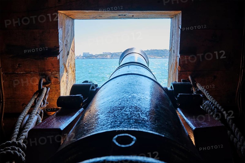 Sea view out of a gunport over the gun cannon muzzle on the gun deck of a Age of Sail sailing ship