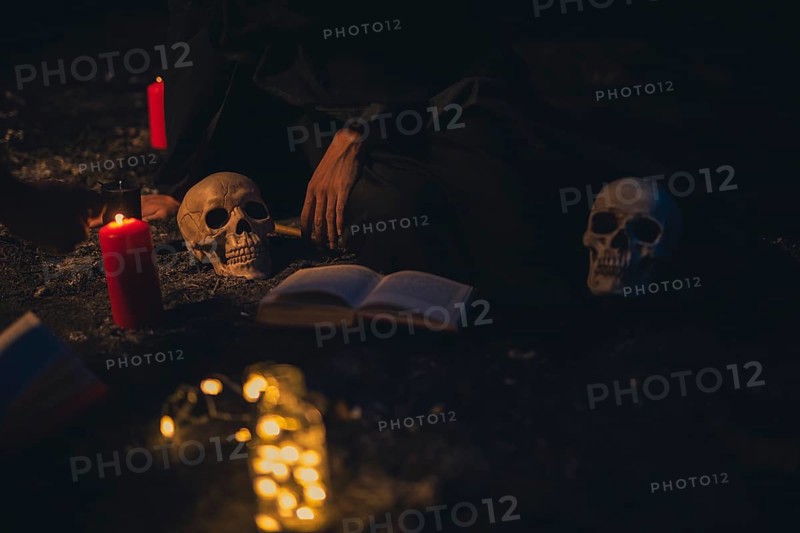 Witchcraft arrangement with candle lights dark