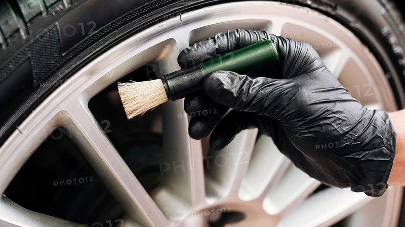Man cleaning car rims
