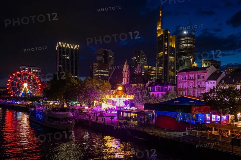 The colourful lights of the Mainfest shine in the evening. The Mainfest on the Mainkai