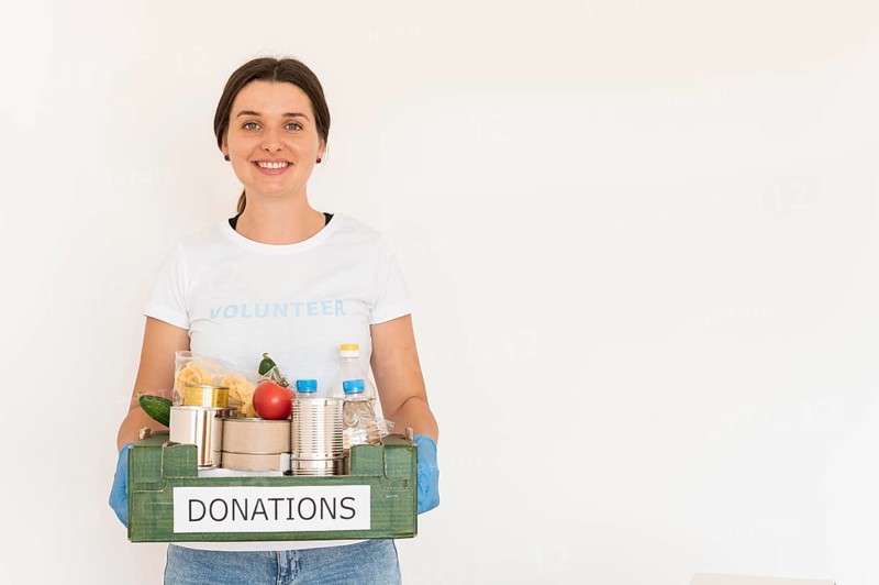 Female volunteer gloves handling box food donations