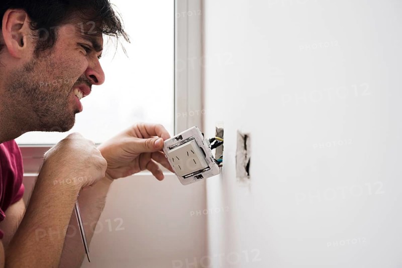 Close up male electrician working home
