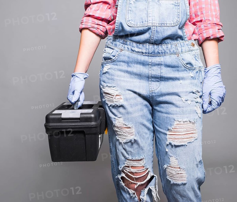 Woman overall holding tool box