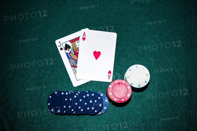 Jack spade heart ace card with casino chips stack green poker table